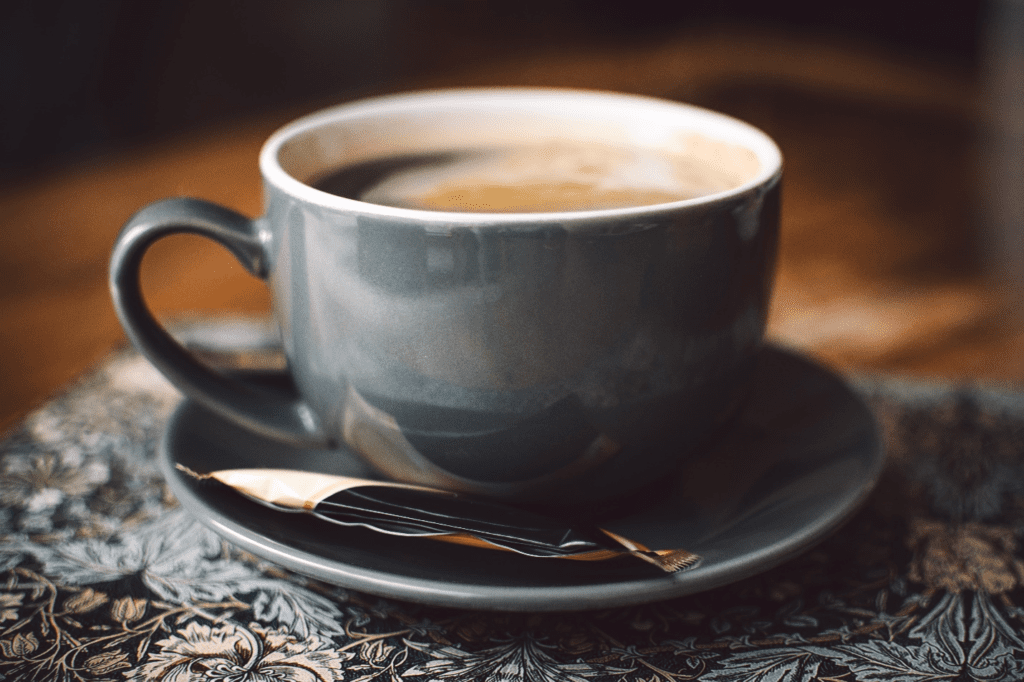 Cup of hot coffee with a sugar packet